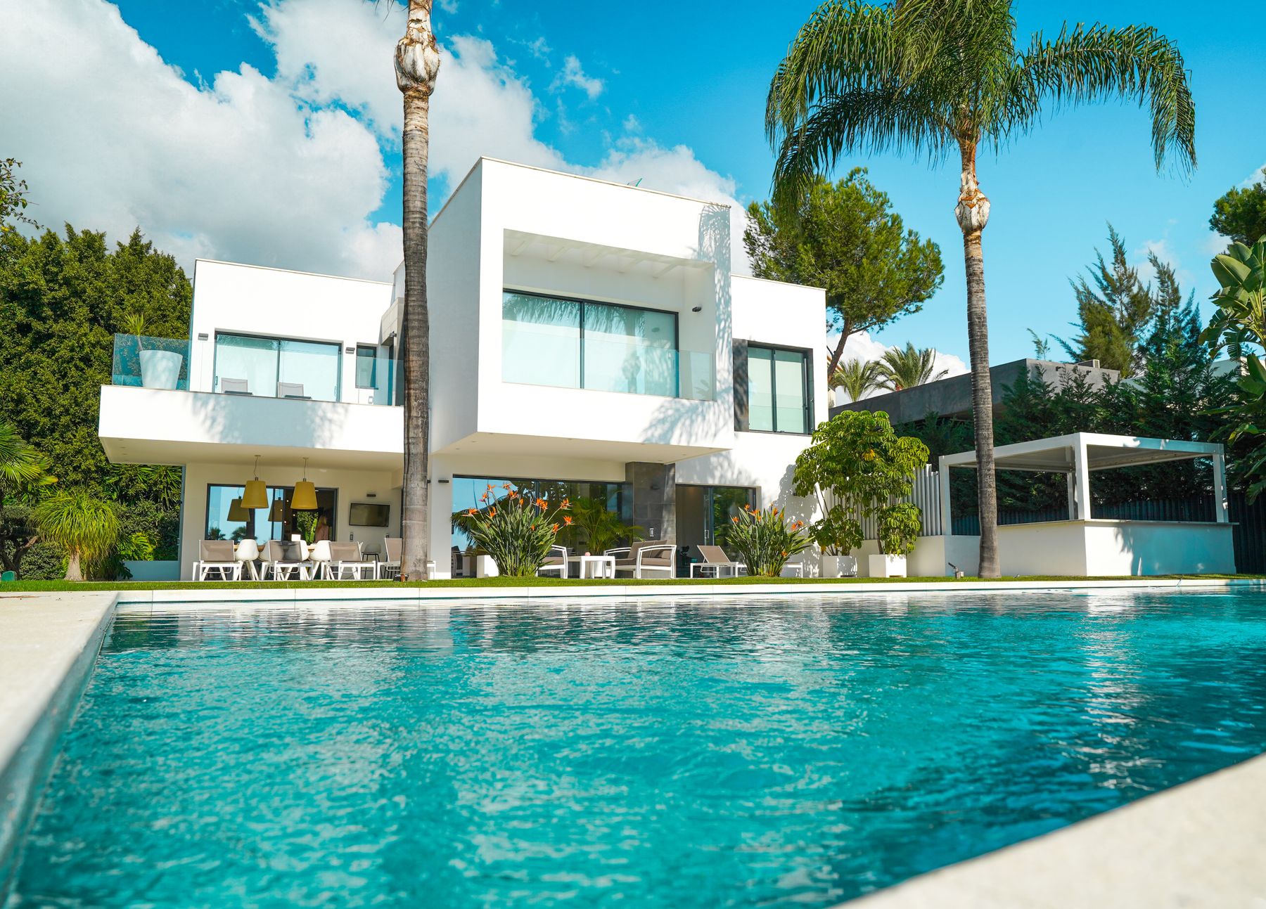 A contemporary villa with a pool in a sunlit garden — illustrative photography